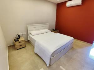 PoringalkuthuLGR Club House的卧室配有白色的床和红色的墙壁