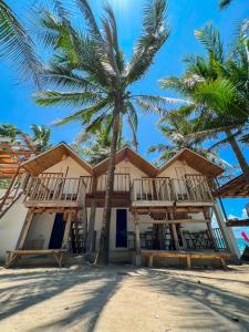 GubatPipa de Playa Resort Café的棕榈树海滩上的度假村