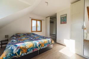 普卢阿La maison d'Alphonse : Plouha, proche de la plage的一间卧室配有一张带彩色毯子的床