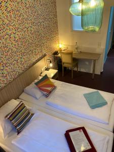 萨尔布吕肯玛德琳纳拜尔酒店的酒店客房设有两张带桌子和桌子的床。