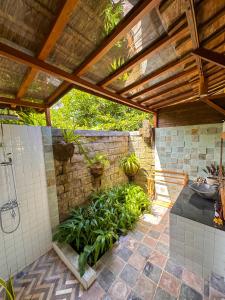 坎古Nunu Bali Eco Friendly Retreat的带淋浴的浴室和石墙
