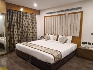 钦奈Hotel Benzz Park Chennai的一间卧室设有一张大床和一个大窗户