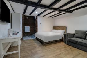 AstwickOYO Tudor Oaks Lodge Stevenage North的一间卧室配有一张床和一张沙发