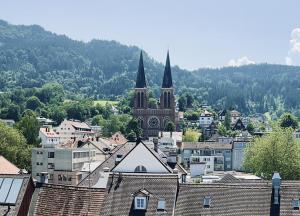 布雷根茨kleiner Löwe – Stadthotel Bregenz的教堂背景的城市景观