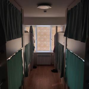 阿拉木图Hostel Nomad的走廊上设有窗户,位于带摊位的房间