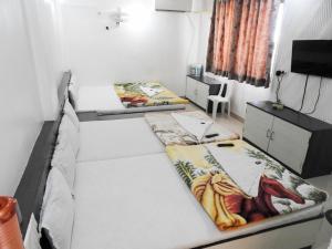 舍地Hotel Shree Sai Darshan的一间设有两张床和一台电视的房间