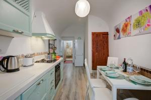 多利亚尼Dogliani Borgo Castello - Happy Rentals的厨房配有白色的柜台和桌椅