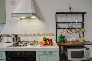 多利亚尼Dogliani Borgo Castello - Happy Rentals的厨房配有炉灶以及水果和蔬菜水槽。