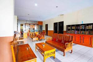 BungurasihOYO 91415 De Wijaya Hotel的带沙发、椅子和桌子的客厅