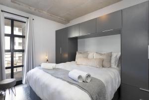 布鲁堡史特兰Manhattan on Coral 7的一间卧室配有一张大床和两条毛巾
