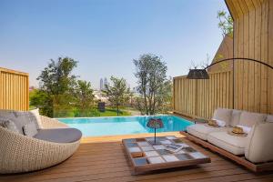 多哈Katara Hills Doha, Lxr Hotels & Resorts的一个带两把椅子和一张桌子的庭院和一个游泳池