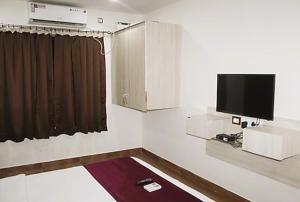 GoaAravind Residency Calangute的墙上配有平面电视的房间