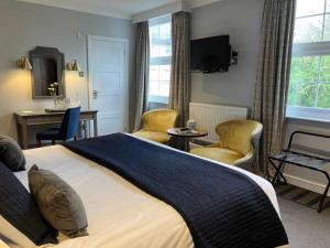 法尔茅斯力推布杜克维恩酒店的一间卧室配有一张大床、椅子和书桌
