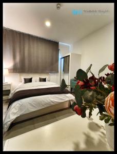 安曼Weibdeh Heights Apartments的一间卧室配有床和花瓶