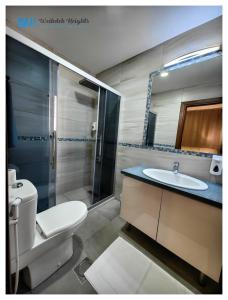安曼Weibdeh Heights Apartments的浴室配有卫生间、盥洗盆和淋浴。