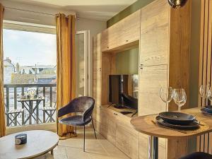 多维尔Le Longchamp的客厅配有桌子和电视