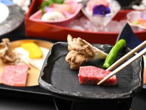 大津豫兹昂索酒店的配以寿司和筷子的食品