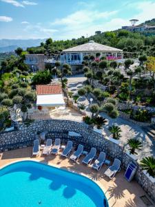 马萨鲁布朗斯Hotel Villa Lubrense Sorrento的享有带游泳池和椅子的度假村的空中景致