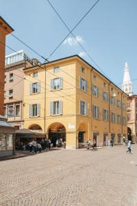 摩德纳Molinari House Modena Centro Diamond的鹅卵石街道上一座大型黄色建筑
