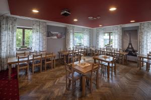 Ujčov祖布尔酒店的用餐室配有木桌和椅子