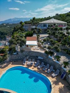 马萨鲁布朗斯Hotel Villa Lubrense Sorrento的享有游泳池和椅子以及度假村的景色