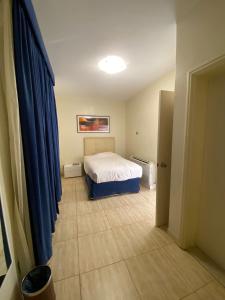 半月湾Dana Beach Resort منتجع شاطئ الدانة的一间卧室配有床和蓝色窗帘