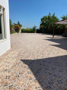 半月湾Dana Beach Resort منتجع شاطئ الدانة的一个带石头地板和桌子的庭院