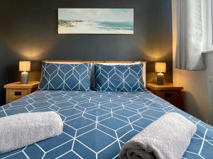 本莱赫Bungalow33 Benllech的一间卧室配有一张带两盏灯的蓝色床。