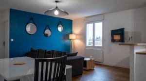 普瓦捷La petite Roche - Spacieux T2 à Poitiers的客厅配有桌子和蓝色的墙壁