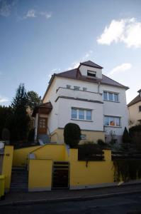 耶拿Kernberg Apartment Jena的前面有黄色围栏的白色房子
