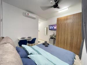 雪邦Myna Suite & Lenore at Alanis Residence Sepang, KLIA Homestay Apartment的一间卧室配有蓝色的床和电视