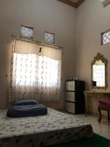 谏义里Griya Erlangga的一间卧室配有床、窗户和梳妆台