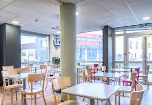 尼姆B&B HOTEL Nîmes Centre Arènes的用餐室设有桌椅和窗户。