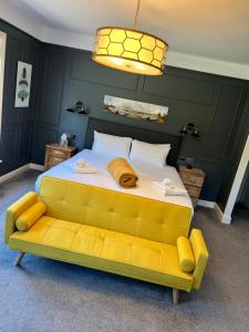 马舍姆耕地旅馆的一间卧室配有一张大床和一张黄色沙发