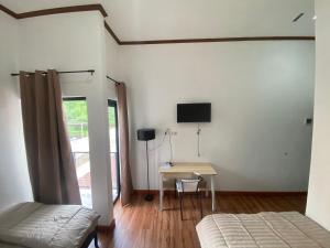 巴厘巴板EMWEKA Residence Balikpapan的一间卧室配有一张桌子和一台墙上的电视。