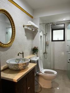 曼谷Quinstel Hostel的一间带水槽、卫生间和镜子的浴室