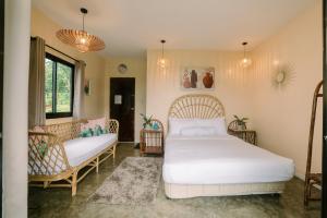 MajayjaySamkara Restaurant and Garden Resort的卧室配有白色的床和沙发