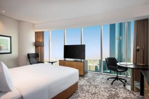 利雅德Hilton Riyadh Olaya的配有一张床和一台平面电视的酒店客房