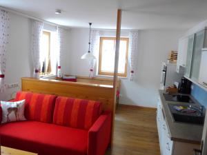 斯拉德明Appartement Romana - Altstadt的一间带红色沙发的客厅和一间厨房
