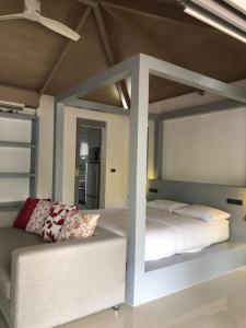 苏梅岛Baan Bangrak Garden的一间卧室配有高架床和沙发