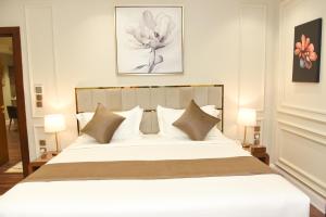 哈费尔巴廷Rose Bark - روز بارك的卧室配有带枕头的大型白色床