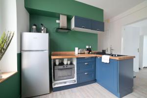 普瓦捷Le Relais Poitevin - Grand T3 proche gare的厨房配有蓝色橱柜和白色冰箱