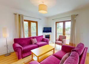 基拉卢Lakeside HH No 30 - 2 Bed的客厅配有紫色沙发和电视