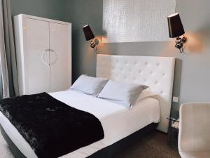 尼姆劳亚尔酒店的卧室配有一张带黑色毯子的白色床