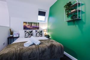 利物浦Charming abode near city centre/free parking的一间卧室设有一张大床和绿色的墙壁