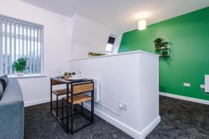 利物浦Charming abode near city centre/free parking的客厅设有绿色的墙壁和桌子