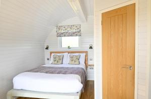 格拉斯哥Luxury Glamping Pods - The Heft & The Hirsel的一间小卧室,配有一张床和一扇门