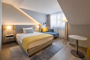 慕尼黑欧洲酒店的卧室配有1张床、1张桌子和1把椅子