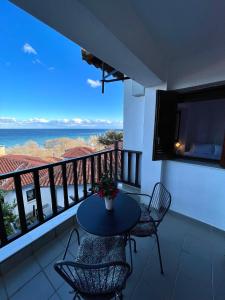阿吉奥斯伊欧尼斯Aegean View House的阳台配有桌椅,享有海景。