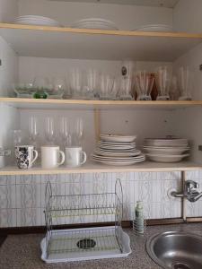希洪La Casa Céntrica Gijón的一个带盘子和玻璃杯的厨房架和水槽